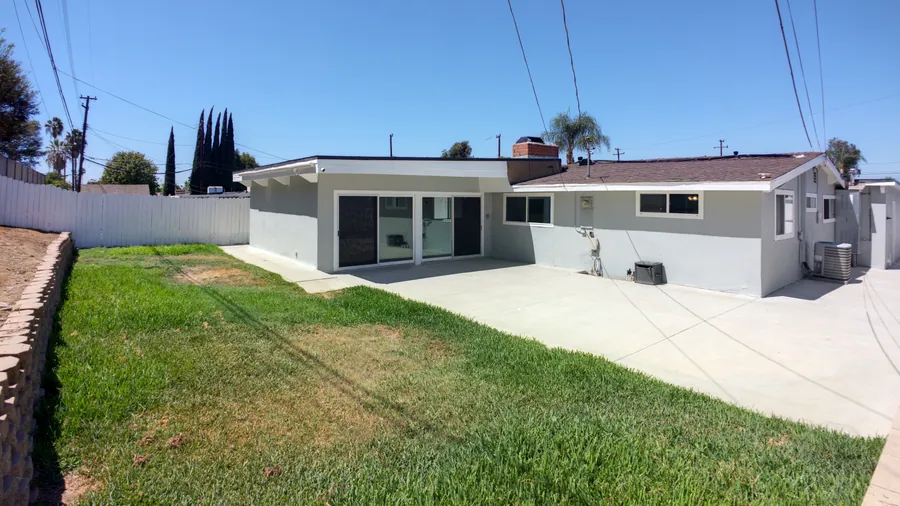 Rear concrete patio spanning the full width of the home